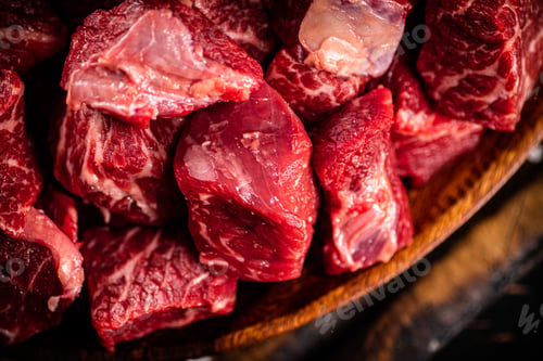 Preview: Raw beef sliced on a dark background.