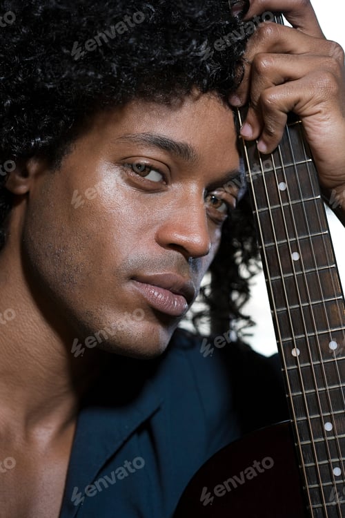 Preview: Musician with an intense gaze holding a guitar