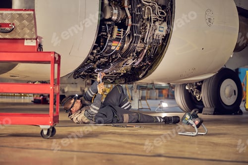 Preview: Ground crew working below a passenger airplane