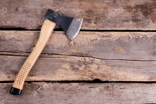 Preview: Top view of an axe on rustic wooden boards.