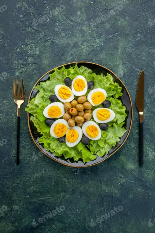 Preview: top view boiled sliced eggs with olives and green salad on dark-blue background food health tea