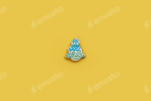 Preview: Gingerbread Christmas cookie with white and blue icing garlands on a yellow background