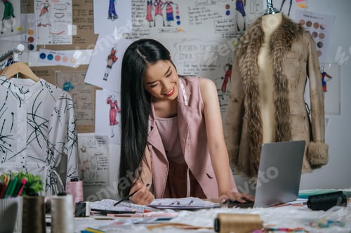 Preview: Young designer use laptop during drawing clothes sketch
