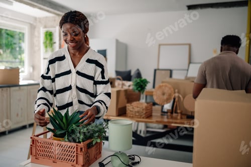 Preview: Couple arranging plants and boxes in new home