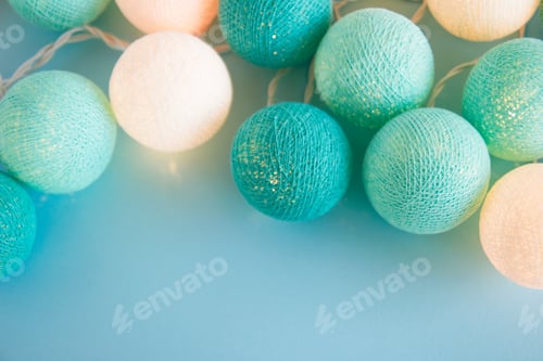 Preview: Blue and white light ball made of yarn threads closeup on the blue background, top view