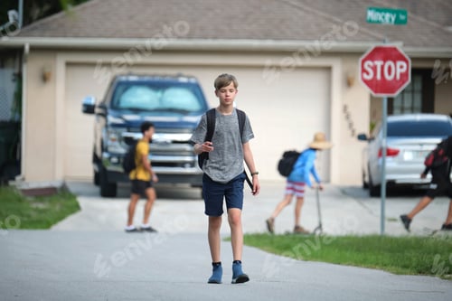 Preview: Young handsome smiling teenager boy with backpack happy going to school on sunny day