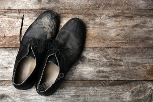 Preview: Dirty shoes and space for text on wooden background, top view. Poverty concept