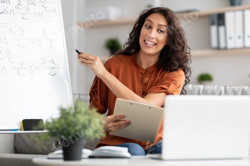 Preview: Female teacher explaining math to students using laptop holding clipboard