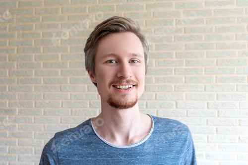 Preview: Smiling young man with red beard.