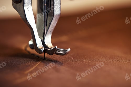 Preview: Machine head with a needle close-up, a sewing machine makes a seam on a piece of leather.