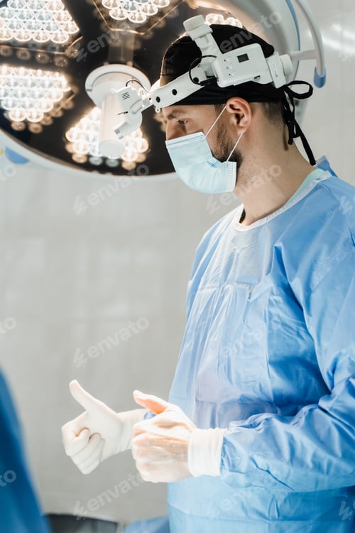 Preview: Surgeon prepares with headlight and gloves for surgery in medical clinic