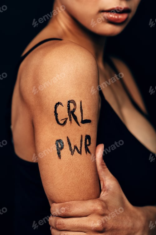 Preview: Studio shot of unrecognizable woman with letters "GRL PWR" on her shoulder