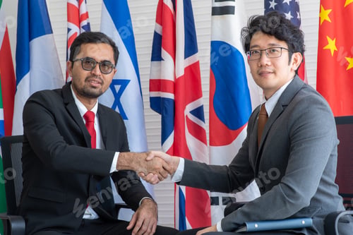 Preview: Business people shake hands, international flag background