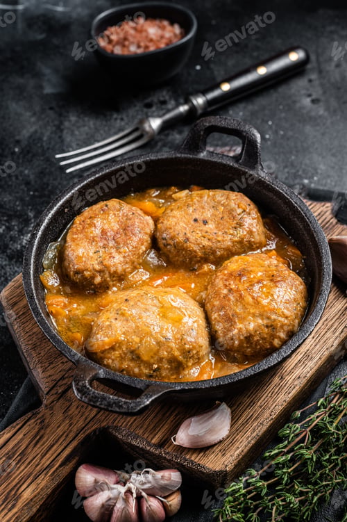 Preview: Fish balls with tuna in tomato sauce in a pan. Black background. Top view