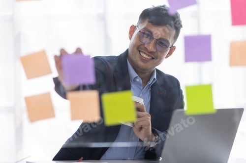 Preview: Concentrated adult business asian man, organizing his busy work week in the office. documents money