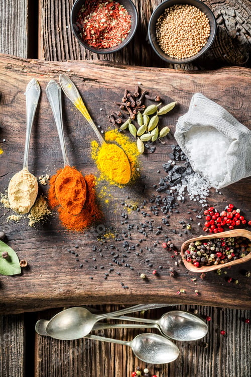 Preview: Colorful herbs and spices with spoons on old board