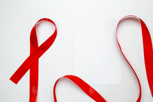 Preview: Red ribbon with awareness about AIDS on a white background and paper for mock up. World AIDS Day