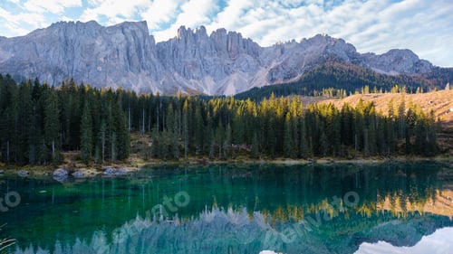 Preview: Enchanting reflections of Dolomite peaks by a serene alpine lake at golden hour