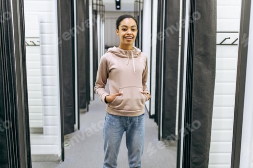 Preview: Woman standing in fitting room, clothing store
