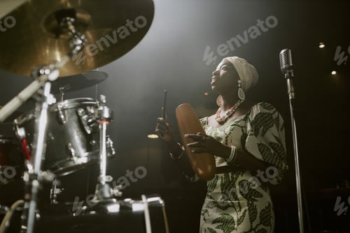 Preview: Young Black Woman Singing And Playing Guira