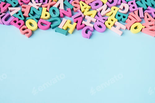Vorschau: Viele verstreute mehrfarbige Buchstaben auf blauem Hintergrund. Lesen lernen, Alphabet.