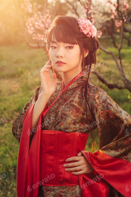Preview: Portrait of beautiful asian woman in blooming park at sunset