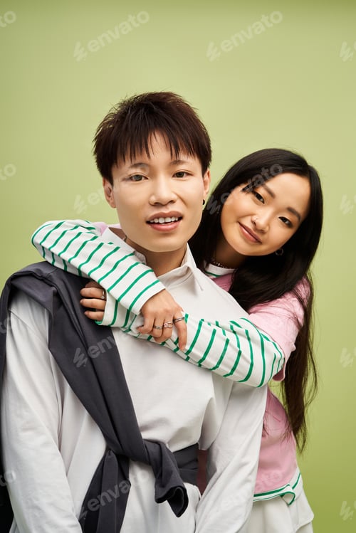 Preview: Stylish couple sharing a loving moment in contemporary fashion against a soothing green backdrop