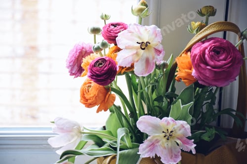 Preview: Bouquet of bright and colorful spring flowers in a yellow leather tote standing by a patio door
