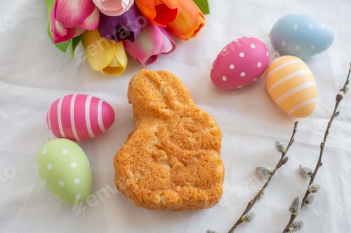 Preview: Top view of a bunny-shaped biscuit surrounded by eggs decorated for the Easter