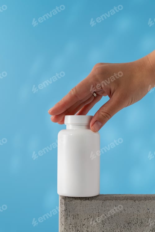 Preview: A woman's hand reaches for a white jar with pills or vitamins on the podium. Medical preparations.