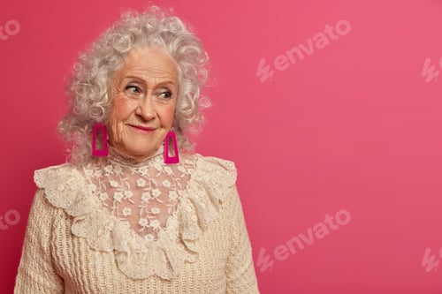 Preview: People, aging and cosmetology concept. Wrinkled grey haird senior woman gazes delighted aside, wears