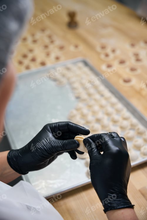 Preview: Woman makes dumplings on a large wooden table