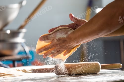 Preview: Closeup shot of a man making roti flatbread in a kitchen