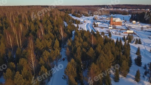 Preview: Top view of snowmobile and village in forest in winter. Clip. Cinematic view of snowmobile going to