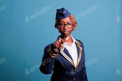 Preview: African american air hostess pointing straight at camera