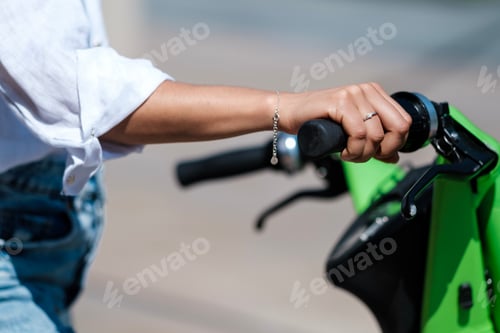 Preview: Female hand holding electric cycle handle.