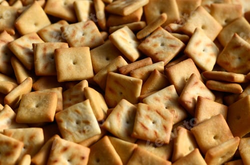 Preview: Background texture of small edible squares baked from dough and sprinkled with salt