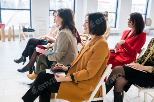 Visualização: Grupo de mulheres sentadas na plateia para treinamento de negócios