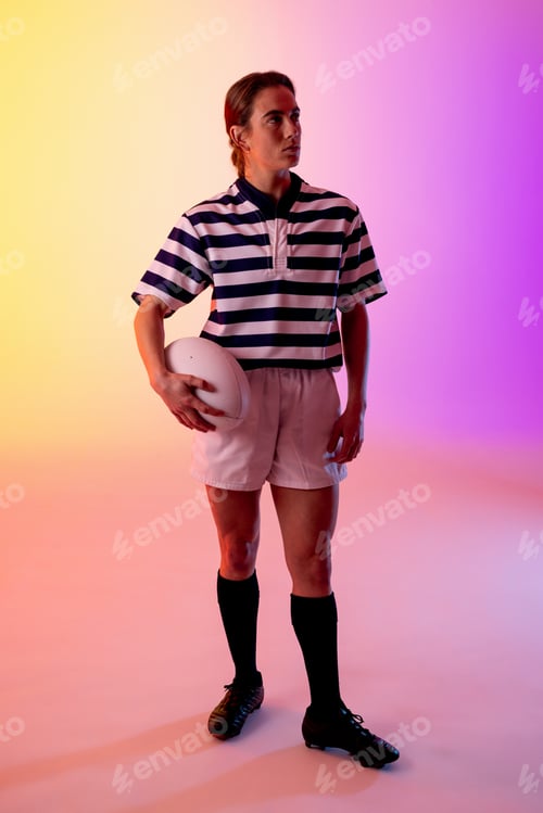 Preview: Caucasian female rugby player with rugby ball over neon pink lighting