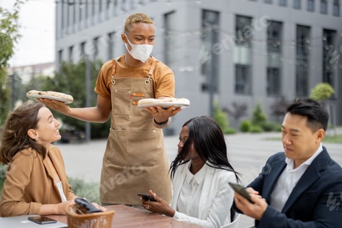 Preview: Business team having lunch at outdoor cafe