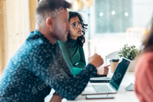Preview: Smart business people working together with laptop while talking in the coworking place.