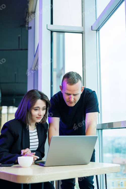 Preview: Young colleagues work in a spacious office and look at the computer. Successful people