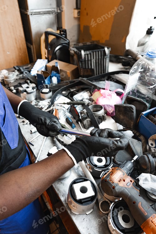 Preview: Close up of hands of auto mechanic working in a garage