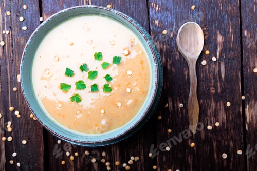 Preview: Pea soup in green bowl on brown wooden background. Top view. Dry yellow pea. Vegan food.