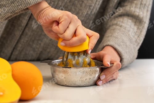 Preview: Female squeezing fresh orange juice with manual stainless steel citrus juicer
