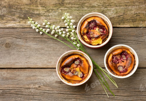 Preview: Cottage cheese dessert baked in portioned round ceramic plates on a wooden table
