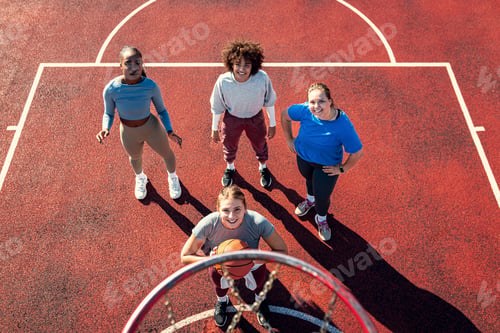 Preview: Portrait of diverse group of young woman having fun playing basketball outdoors.