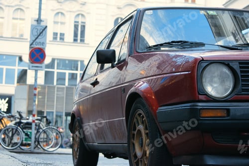 Preview: Closeup shot of a small red car parked outdoors during the day