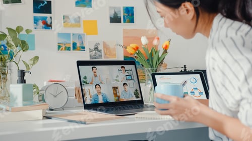 Preview: Young asia female employee listen leader on video call with colleagues with laptop at home.
