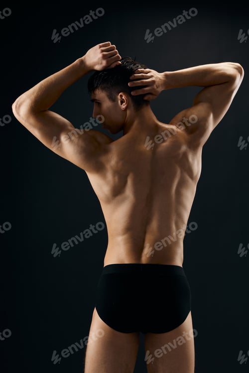 Preview: male athlete posing on dark background back view
